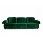 Green velvet sofa with soft cushions and two matching bolsters showing modern cozy design.
